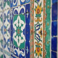 Traditional Persianstyle mosaic wall adorned with intricate geometric and floral patterns on an Iran blue ceramic tile backdrop photo