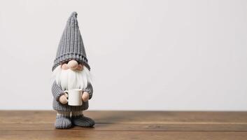 Adorable gnome figurine grayclad mugholding stands on wooded surface photo