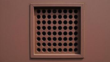Rusty metal panel with rectangular vent circular hole pattern photo
