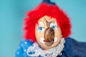 Snail walking on the face of a clown model. photo