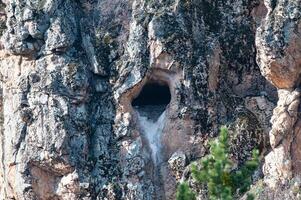 A cave with a hole in the side of it photo