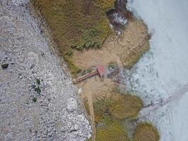 An aerial view of a small building in the middle of a field photo