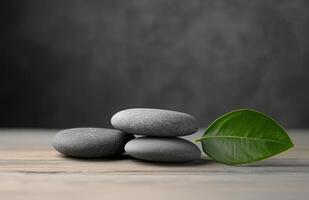 Relaxing stack of smooth stones with a green leaf on a wooden surface for wellness aesthetics photo