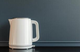 Modern white kettle on a kitchen counter against a textured gray background photo