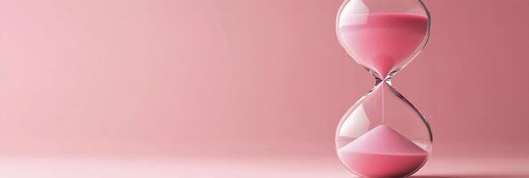 Elegant pink hourglass on a soft pastel background showcasing the passage of time photo