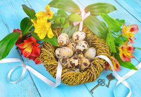 Spring background. Bouquet of flowers on a wooden background and a nest with eggs. spring photo