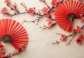 Elegant red folding fan accompanied by blossoming cherry branches on a soft background photo