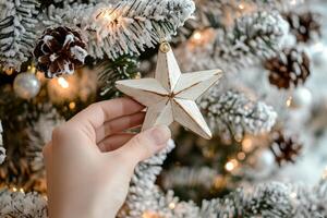 Decorating a festive tree with a handmade star ornament during the holiday season photo