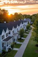 Charming modern townhouses with a sunset backdrop in a serene neighborhood during evening hours photo