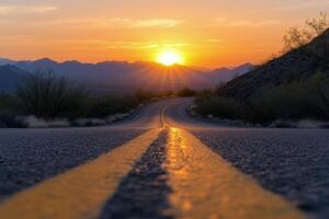 The winding road leading to a vibrant sunset over the mountains in the desert landscape photo