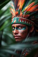 An indigenous man adorned with vibrant feathers and face paint, poised in lush greenery photo