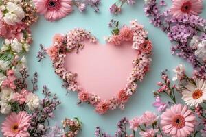 Heart shaped floral arrangement on a blue background with pink blossoms and greenery photo