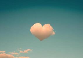 Heart shaped cloud floating in a clear blue sky during a sunny day with fluffy white clouds photo