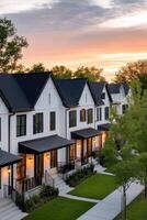 Charming modern townhouses with a sunset backdrop in a serene neighborhood during evening hours photo