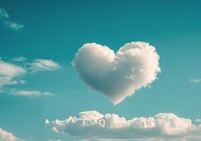 Heart shaped cloud floating in a clear blue sky during a sunny day with fluffy white clouds photo