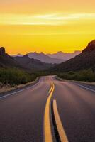 Scenic highway winding through mountains at sunset with vibrant sky and soft shadows photo