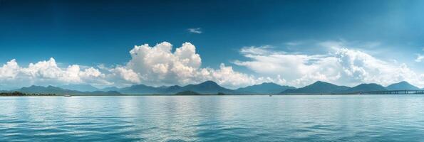 A tranquil view of calm waters under a blue sky and fluffy clouds during the day photo
