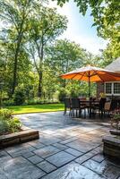 Cozy outdoor dining area with an umbrella surrounded by greenery in a serene backyard setting photo