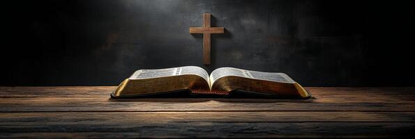 An open Bible resting on a wooden surface with a cross illuminated by soft light photo