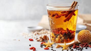 Warm herbal tea with goji berries and spices served in a glass cup on a winter day photo