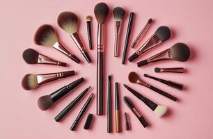 Elegant arrangement of diverse makeup brushes in a circular layout on a soft pink backdrop photo