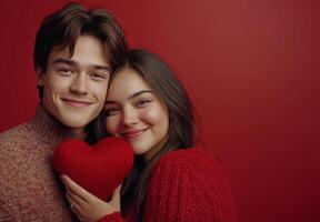 Pareja sonriente juntos mientras participación un corazón conformado almohada en un acogedor ajuste foto