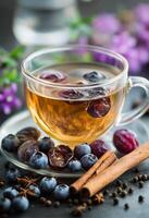 Aromatic herbal tea with dried fruits and spices surrounded by vibrant flowers and berries photo