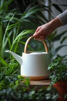 A person watering plants with a stylish white and wooden watering can in a lush indoor garden photo