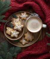 Warm holiday treats with gingerbread cookies and a steaming cup of coffee on a cozy knit backdrop photo