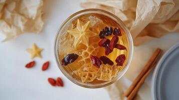 Warm herbal tea with goji berries and spices served in a glass cup on a winter day photo