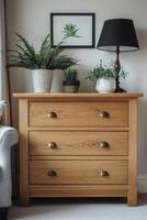 Elegant wooden chest of drawers beside a stylish lamp and indoor plant in a cozy living room photo