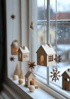 Wooden decorations and miniature houses create a cozy winter atmosphere by the window photo