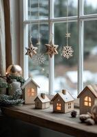 Wooden decorations and miniature houses create a cozy winter atmosphere by the window photo