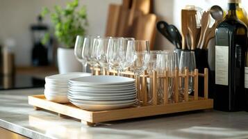 Organized kitchen countertop displaying stacks of clean dishes and glassware in a sunny setting photo