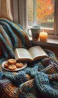 Cozy reading nook with cookies, tea, and a candle by the window on a fall afternoon photo