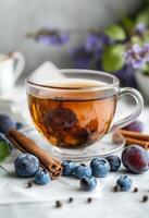 Aromatic herbal tea with dried fruits and spices surrounded by vibrant flowers and berries photo