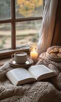Cozy reading nook with cookies, tea, and a candle by the window on a fall afternoon photo