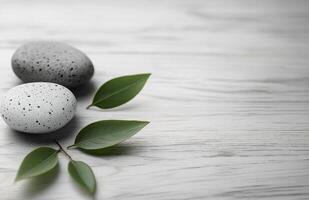 Relaxing stack of smooth stones with a green leaf on a wooden surface for wellness aesthetics photo