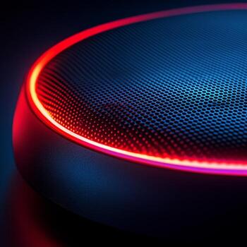 Modern audio speaker illuminated with red and blue lights against a dark background photo