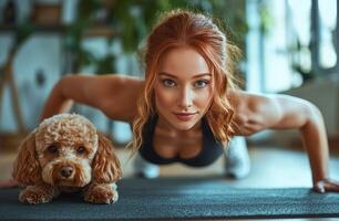 Young woman exercising on a mat at home while playfully interacting with her dog photo