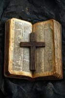 A wooden cross rests above an open Bible on a rustic table in soft light, symbolizing faith photo