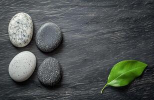 Relaxing stack of smooth stones with a green leaf on a wooden surface for wellness aesthetics photo