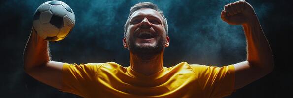 A soccer player passionately celebrating a goal in a dimly lit environment during a night match photo