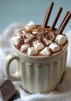 Warm hot chocolate with marshmallows and chocolate sticks in a cozy winter setting photo