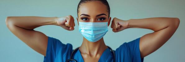 A determined healthcare professional flexes muscles while wearing a blue medical mask photo