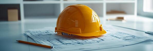 Bright yellow hard hat rests on construction plans in a well lit modern workspace photo