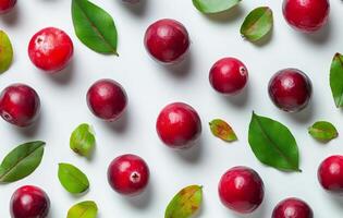 Fresh cranberries and green leaves arranged on a light background in an artistic display photo