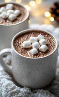 Warm hot chocolate topped with marshmallows beside cozy lights in a winter setting photo