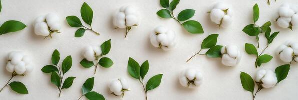 Cotton bolls and green leaves arranged aesthetically on a light background for floral decoration photo