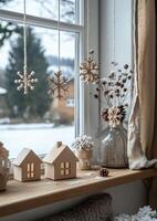 Wooden decorations and miniature houses create a cozy winter atmosphere by the window photo